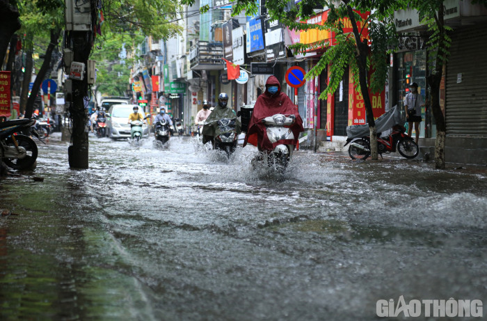 Người dân "rẽ sóng" qua những tuyến phố ngập tại Hà Nội