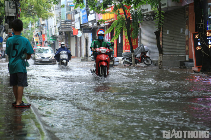 Người dân "rẽ sóng" qua những tuyến phố ngập tại Hà Nội