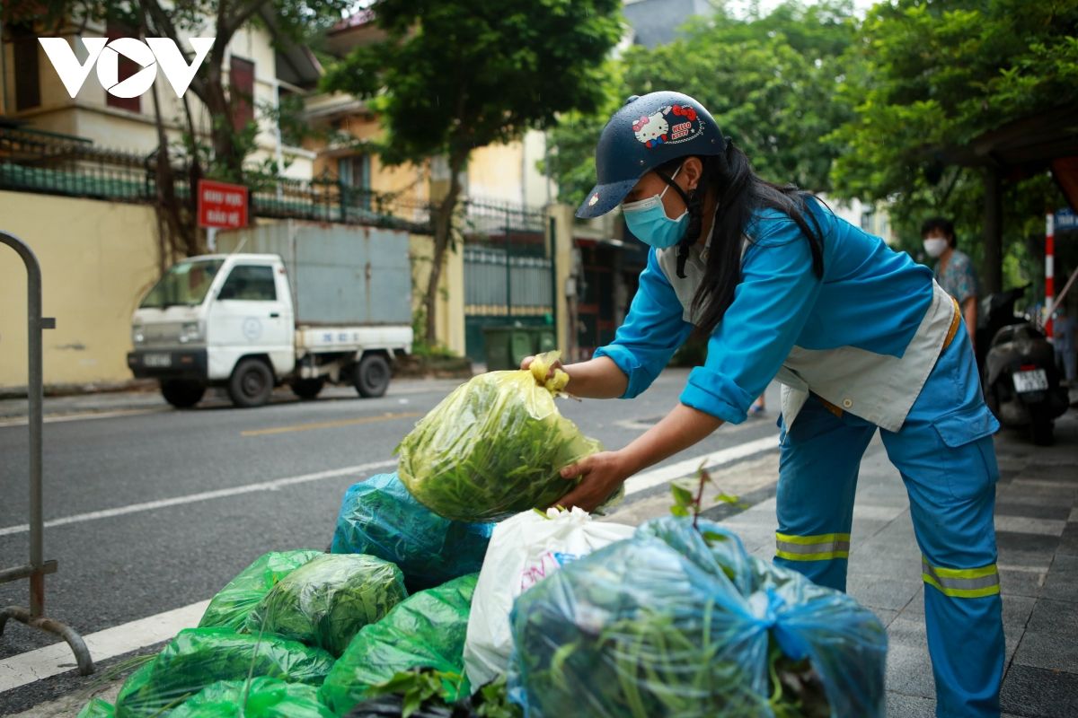Nữ lao công vừa quét rác vừa phát rau miễn phí cho người gặp khó khăn vì dịch Covid-19