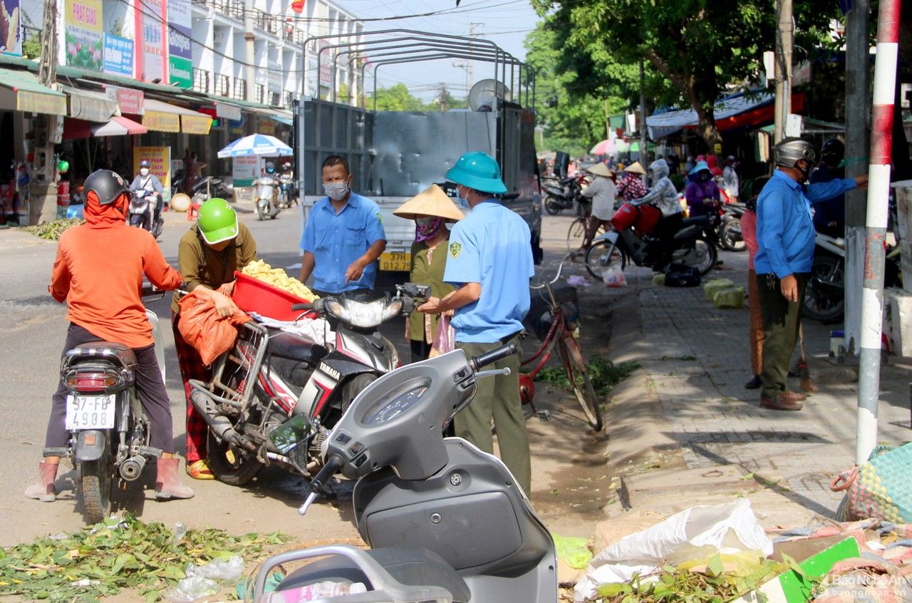 Người dân chen chúc mua bán hàng trước cổng chợ đầu mối Vinh