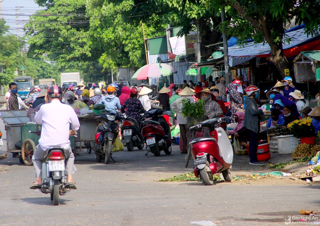 Người dân chen chúc mua bán hàng trước cổng chợ đầu mối Vinh