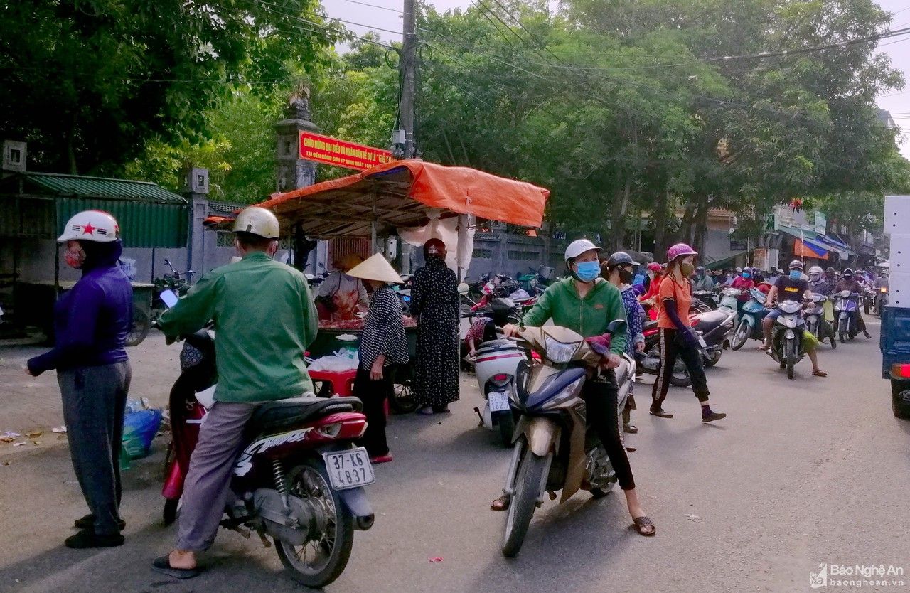 Người dân chen chúc mua bán hàng trước cổng chợ đầu mối Vinh