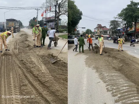 CSGT cùng người dân nhanh chóng thu gom cát rơi vãi trên đường